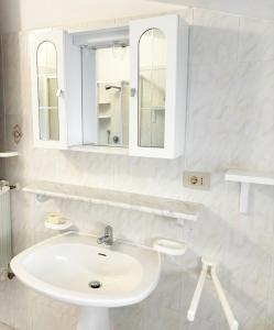 Baño blanco con lavabo y espejo en Villa Blick en Guardistallo