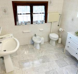 Baño blanco con lavabo y aseo en Villa Blick en Guardistallo