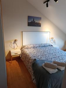 1 dormitorio con 1 cama con edredón azul en Apartamento a estrenar en A Pobra do Caramiñal en Pobra do Caramiñal