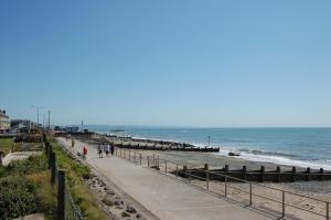 people walking on the beach near the ocean at Ty Traeth Beach House in Tywyn