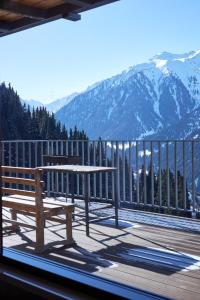 a bench on a deck with a view of mountains at Karakol Resort in Karakol
