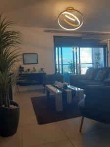 a living room with a couch and a table at Panorama superieur in Netanya