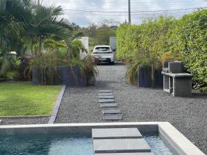 une voiture garée dans un parking à côté d'une piscine dans l'établissement Guadeloupe Evasion Passion, à Saint-François