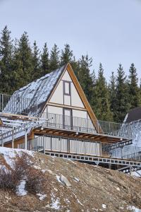 a house with a metal roof on top of a hill at Karakol Resort in Karakol