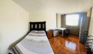 a bedroom with a bed and a desk in it at DEPARTAMENTO CON 3 DORMITORIOS in Huánuco