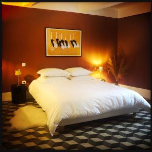 1 dormitorio con 1 cama blanca grande con pájaros en la pared en B&B Vigne Vierge, en Aigne