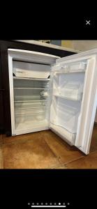 an empty refrigerator with its door open in a kitchen at Apartamentos en Alfacar in Alfacar