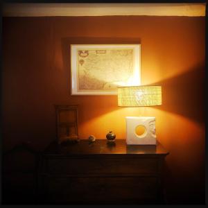 una lámpara en una mesa con un mapa en la pared en B&B Vigne Vierge, en Aigne