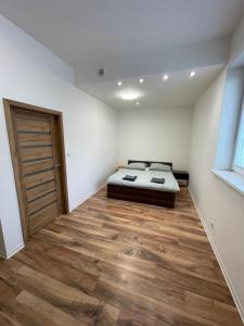 a bedroom with a bed and a wooden floor at Komfortné bývanie s garážou alebo parkovaním in Žilina