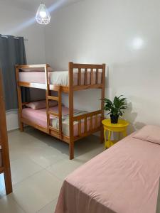 um quarto com 2 beliches e um vaso de plantas em Apuama Hostel em Ubajara