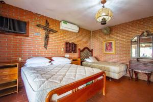 1 dormitorio con 2 camas y pared de ladrillo en Scenic Mountain Stay, en La Guardia