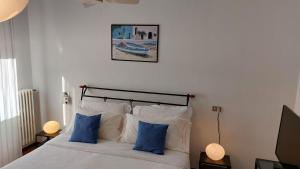 ein Schlafzimmer mit einem Bett mit zwei blauen Kissen in der Unterkunft Antonia's Guest House in Rimini