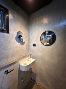 Un baño con un lavabo y un espejo en la pared. en Naramountainkhaoyai รถบ้าน, en Ban Tha Chang