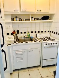a kitchen with a white stove and a sink at Stylish Montreal Apartment: Comfortable Stay in the Golden Square Mile in Montreal