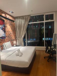 Soho Suites KLCC By Inam Suites في كوالالمبور: غرفة نوم بسرير وجدار من الطوب