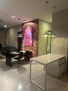 Soho Suites KLCC By Inam Suites في كوالالمبور: غرفة معيشة مع طاولة وجدار من الطوب