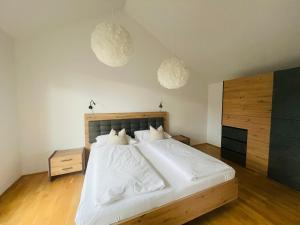 a bedroom with a large white bed with white sheets at APSTAY Eggenberg I Self Check-in I Parking in Graz +130 photos