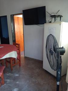 a room with a fan and a tv on a wall at Bosquecito de Carpin in Carpintería