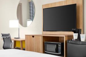 a hotel room with a television and a bed at Days Inn by Wyndham Paris in Paris