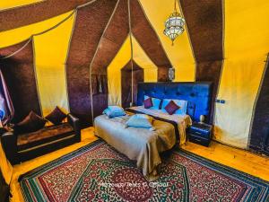 1 dormitorio con 2 camas y sofá en Merzouga Tents © Official en Merzouga