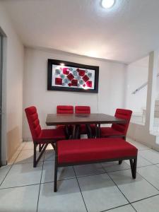 une salle à manger avec une table et des chaises rouges dans l'établissement Casa a solo 5 min del parian y 20 min aeropuerto, à Guadalajara