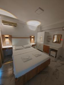 a bedroom with a large bed and two windows at ALİBABAM APART OTEL in Kuşadası +27 photos