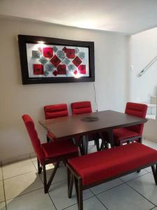 une table à manger avec des chaises rouges et un tableau dans l'établissement Casa a solo 5 min del parian y 20 min aeropuerto, à Guadalajara