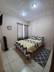 - une chambre avec un lit et une télévision dans l'établissement Casa a solo 5 min del parian y 20 min aeropuerto, à Guadalajara