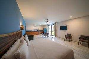 a bedroom with a bed and a living room at Luna Azul Bacalar in Bacalar