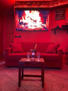 Sala de estar de color rojo con sofá rojo y mesa en Casa Vacanza Relax Sondrio en Sondrio