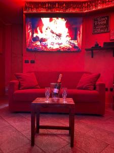 un soggiorno rosso con divano rosso e tavolo di Casa Vacanza Relax Sondrio a Sondrio