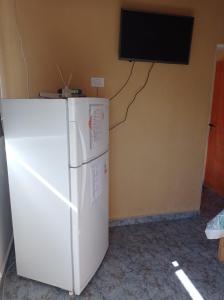 a white refrigerator in a room with a tv on the wall at Bosquecito de Carpin in Carpintería +36 photos