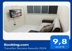een kamer met een bank en een tv aan de muur bij Apartamento aconchegante próximo à UFS in São Cristóvão