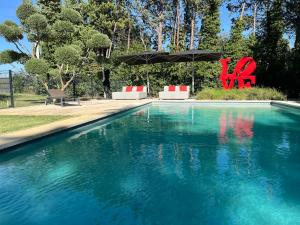 a swimming pool with a chair and an umbrella at Domaine de La Franquette by Bridget & Pascal in Caderousse