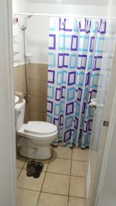 een badkamer met een toilet en een douchegordijn bij ALLEJA CONDOMINIUM in Imus