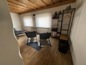 - une chambre avec deux chaises et une échelle dans l'établissement Vidiecky domček, à Pohronská Polhora