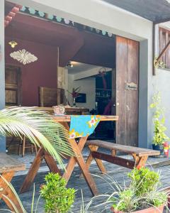 a table and bench in a patio with a kitchen at Hostel das fadas in Paraty