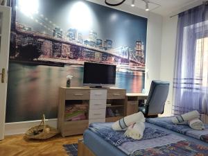 a room with two beds and a tv on a wall at Grand Apartman San with garage in Sarajevo