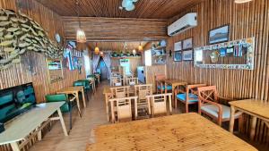 un restaurante con paredes de madera, mesas y sillas en La Maison B&B en Eluan
