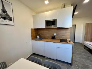 a kitchen with white cabinets and a microwave at Hotel Hangar in Mošnov