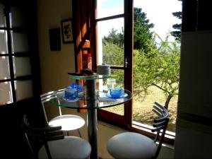 a glass table and two chairs in front of a window at El Calden in Villa Ciudad de America