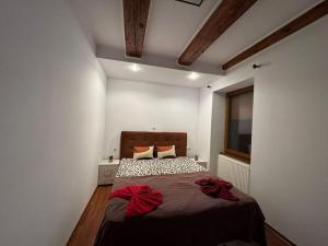a bedroom with a bed with red bows on it at IaZi Apartament in Braşov