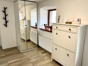 a bathroom with a white dresser and a mirror at Vidiecky domček in Pohronská Polhora