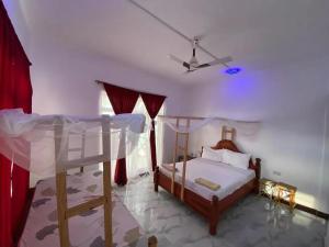Cassandra Beach Resort في نونغوي: غرفة نوم بسريرين بطابقين ومروحة سقف