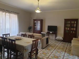 Residenza Sorrentina في سورينتو: غرفة معيشة مع طاولة وأريكة وتلفزيون