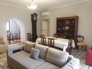 a living room with a couch and a table and a clock at Residenza Sorrentina in Sorrento