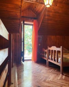 a bedroom in a log cabin with a bed and a window at Vikendica na Drini in Banja Koviljača