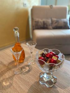 una mesa con un bol de fruta y una botella de alcohol en Apartmani Jaz 24, en Budva