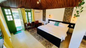 a bedroom with a bed and a table and window at Calm Shack - 2 Bedroom-Boutique Farm Stay in Munnar