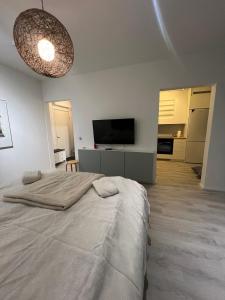 um quarto branco com uma cama e uma televisão em Roomvantaa em Vantaa